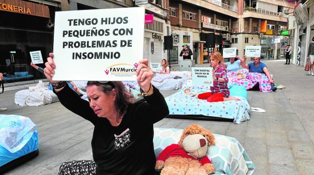 Momento de la 'performance' en la calle Pérez Casas, donde se ve a 'sufridores' del ruido con pancartas a favor del descanso.