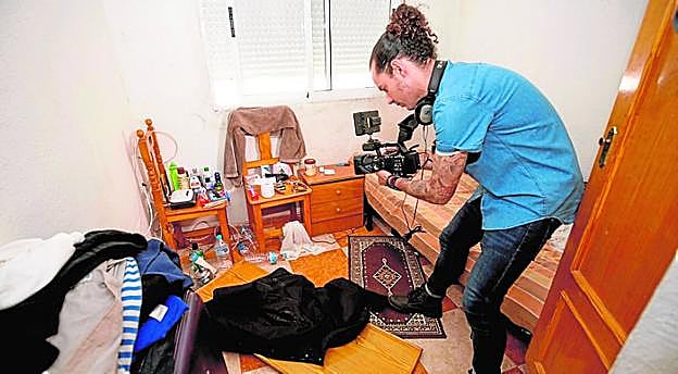 Un cámara graba algunas de las pertenencias del detenido.