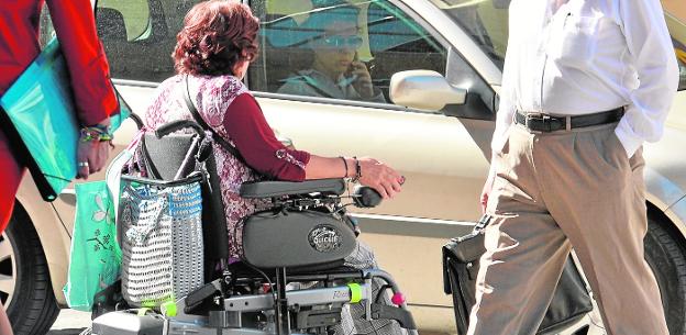 Una vecina de Murcia, ayer por la tarde, circulando por un paso de peatones en silla de ruedas.