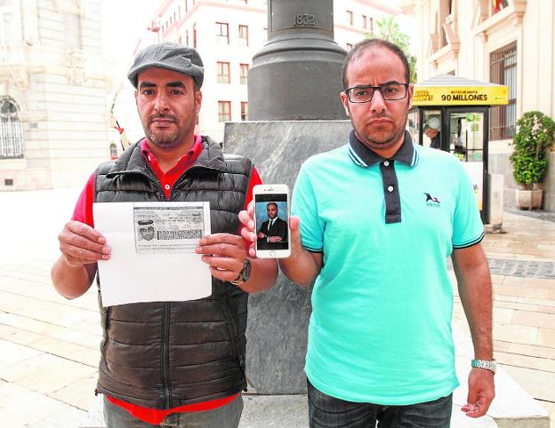 Meshari y Hani Almotairi, con una copia del pasaporte y una imagen de su hermano, en Cartagena.