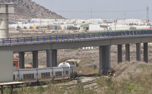 Un tren pasa sobre el futuro trazado del AVE en Cartagena