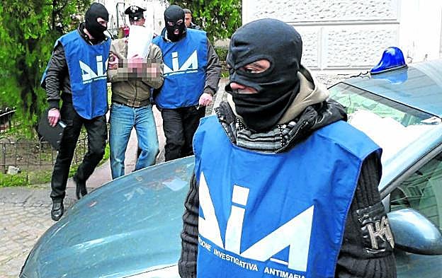 Operativo contra la 'Ndrangheta. Agentes del cuerpo especial contra la mafia detienen a un sospechoso. 