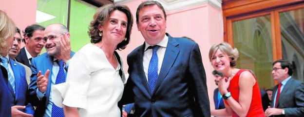 La ministra de Transición Ecológica, Teresa Ribera, y su compañero el ministro de Agricultura, Luis Planas. Detrás, la exministra García Tejerina sonriendo.