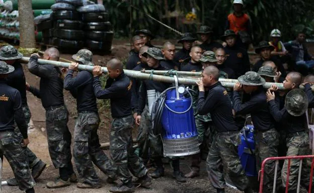 Personal militar transporta una máquina para bombear agua. 