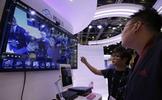 Visitantes observan una pantalla con un sistema de reconocimiento facial en la Global Mobile Internet Conference en Pekín.