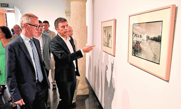 El ministro de Cultura, José Guirao (izq.), junto al director del Centro de la Fotografía de Andalucía, Rafael Doctor (dch.), visitando la exposición que recoge fotografías de los viajes de Goytisolo. 