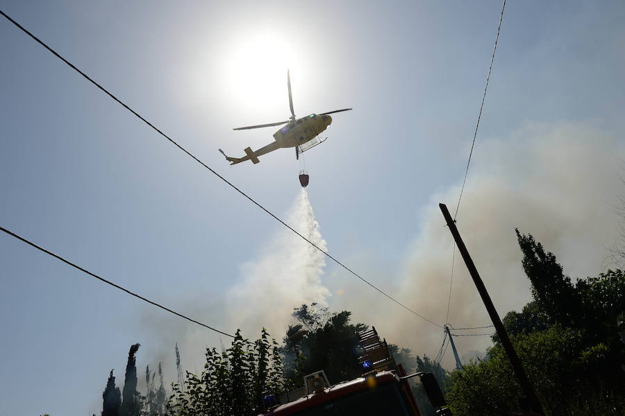 Diversos medios terrestres y aéreos trabajan este viernes contra un incendio declarado en una zona de matorrales tras las cocheras de Latbus