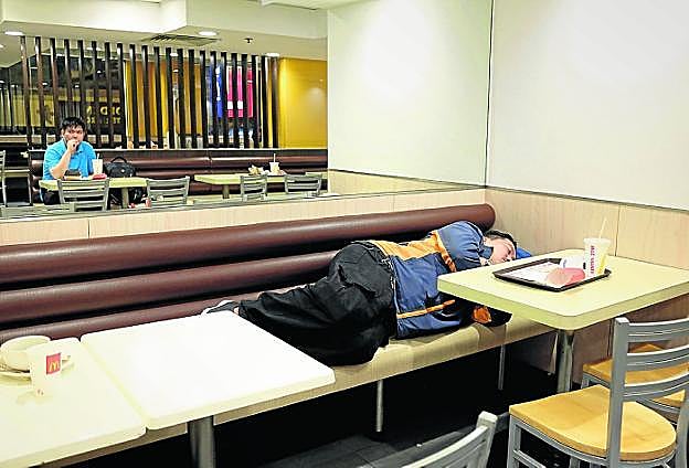 Un hombre pasa la noche en el McDonald's del distrito Sham Shui Po, en Hong Kong. 