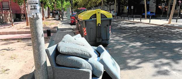 Un sofá abandonado junto a los contenedores de basura de la avenida de la Fama de Murcia. 