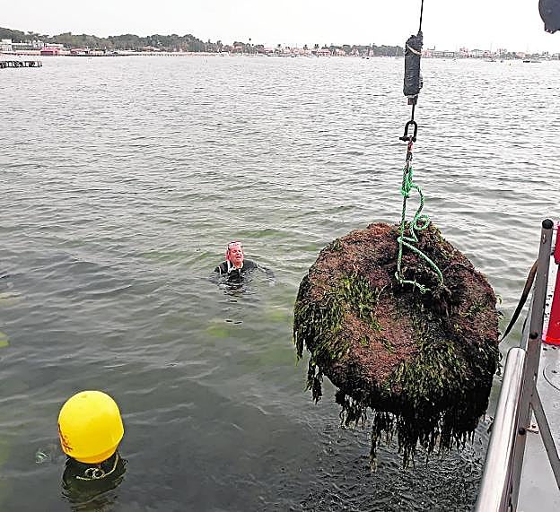 Dos buzos observan uno de los fondeos ilegales que se encontraba en el fondo de la laguna. 