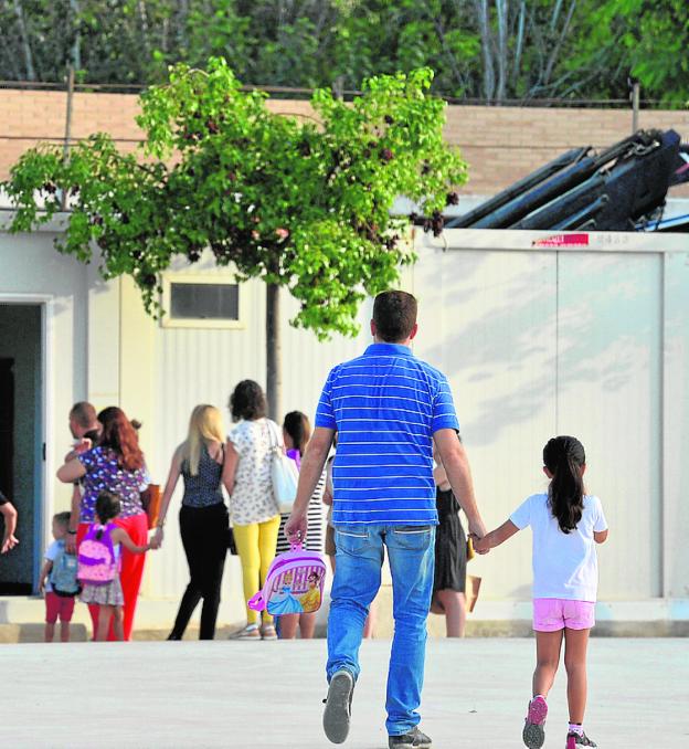 Un padre acompaña a su hija al colegio.