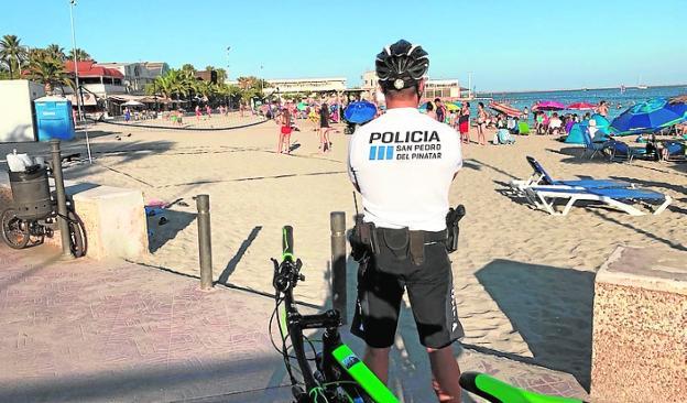 Un agente realiza labores de vigilancia en una playa. 