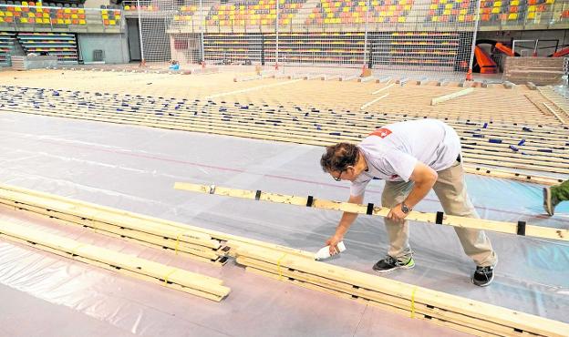 Un operario trabaja en la colocación de la nueva tarima del Palacio de Deportes 