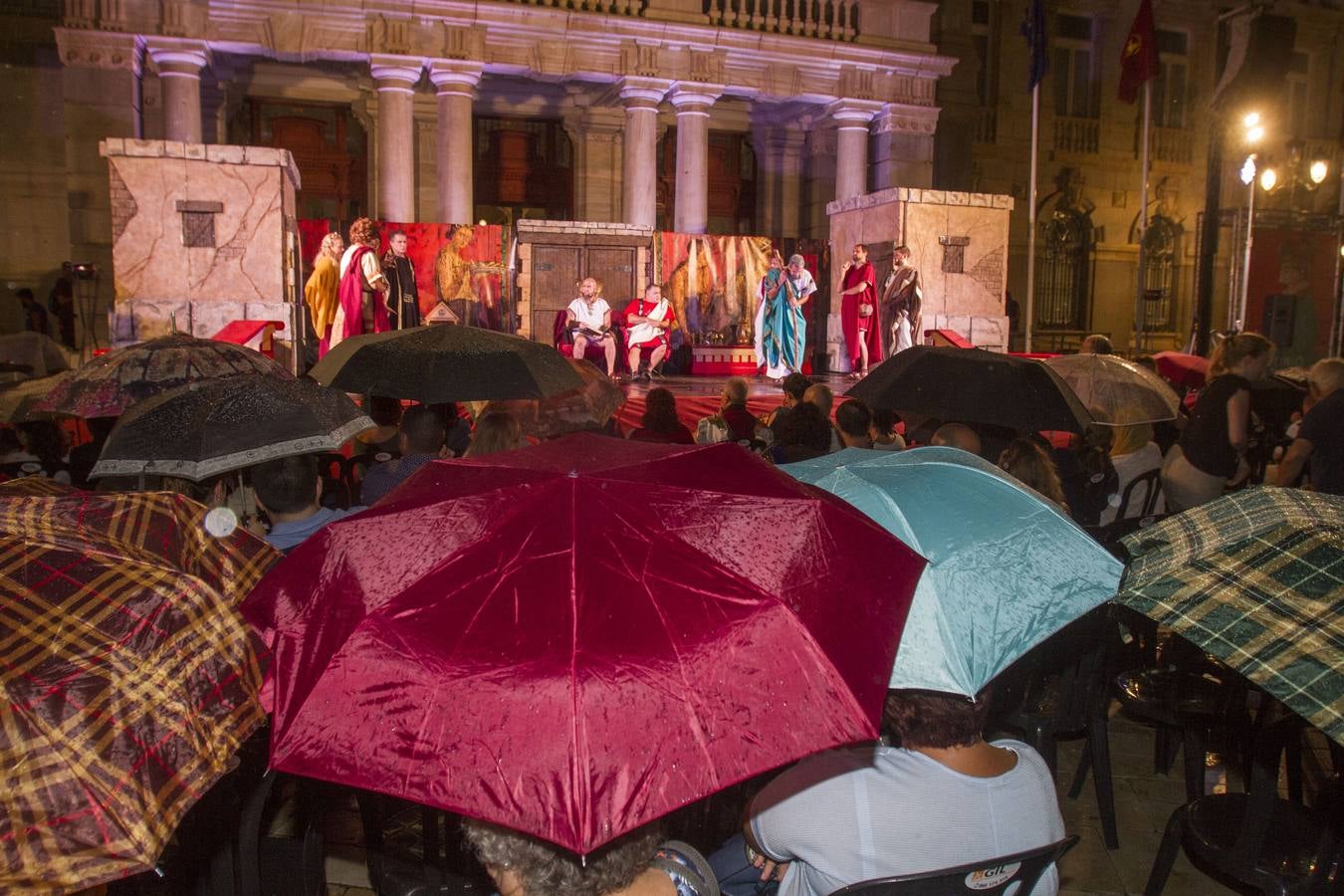 Unas 200 personas resisten la lluvia para ver la reconstrucción en tono de comedia de dos pleitos reales de hace dos mil años en el contexto de las fiestas de Carthagineses y Romanos celebradas en Cartagena.