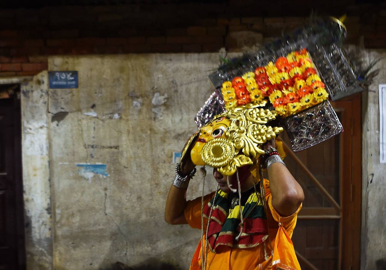 Miles de fieles asisten a las celebraciones del festival Indra Jatra, en Katmandú, Nepal, donde la mujeres se reúnen para beber alcohol casero de la boca del dios Bhairab, bailarines enmascarados danzan representando a las deidades locales y la diosa viviente Kumari, encarnada en una niña, es adorada durante una multidudinaria procesión.