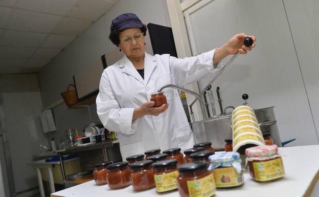 Francisca Ángeles Salar rellena de mermelada de membrillo algunos tarros en su obrador de Abanilla.
