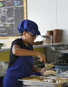 Imagen secundaria 2 - Trabajadores de Foodtopía preparan las comidas que se sirven en los cuatro locales con que cuenta ya este proyecto. | Jesús Pagán, presidente de Foodtopía, muestra una bolsa con el residuo medio diario de una familia de 4 miembros. | Una trabajadora sirve una ración de lasaña vegetal para llevar.