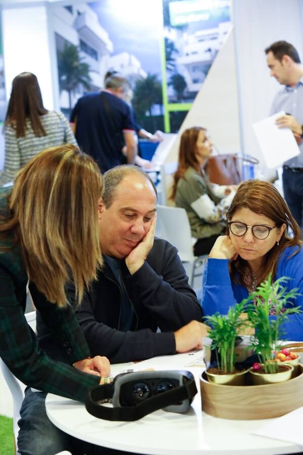 Varios clientes son atendidos en expositores de promotoras en la feria inmobiliaria 'Reside 2018' en el Hotel NH Amistad