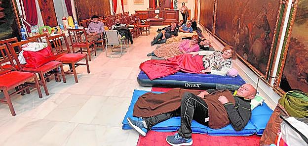 Los damnificados por las ayudas del seísmo dispuestos, en sus improvisadas camas, a iniciar una noche más de encierro en la Sala de Cabildos del Consistorio. 