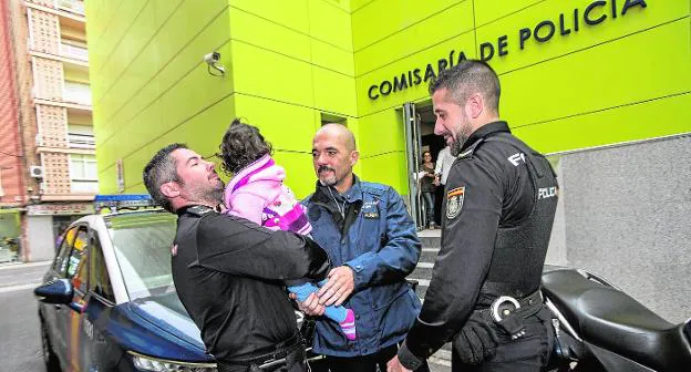 Los agentes Pablo González, Marco Antonio Auñón y Jesús Sánchez, con la niña a la que reanimaron, ayer ante la Comisaría. 