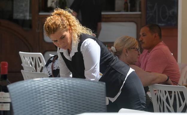 Una camarera trabaja en una terraza en Cartagena.