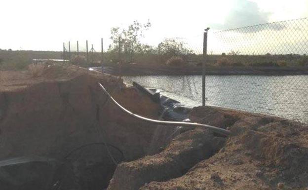 El agua de la balsa se filtra a través de la rotura.