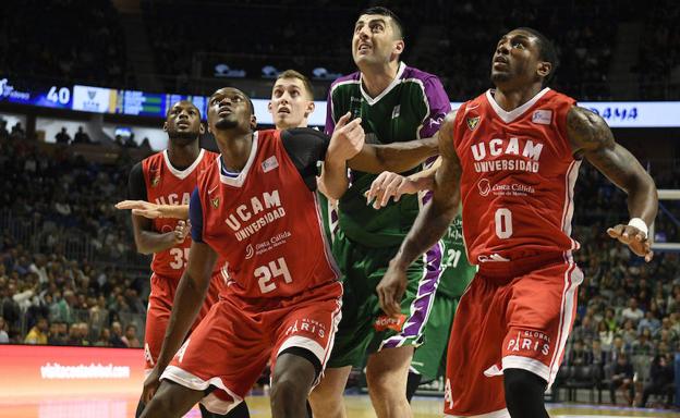 Tumba y Soko, jugadores del UCAM CB, y Shermadini, del Unicaja, luchan por un rebote.