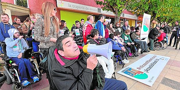 Decenas de personas con movilidad reducida, ayer, en el bloque donde residía la anciana fallecida que reclamaba una rampa accesible. 