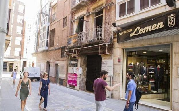 Varios vecinos pasan frente a la promoción de viviendas de la calle Canales.