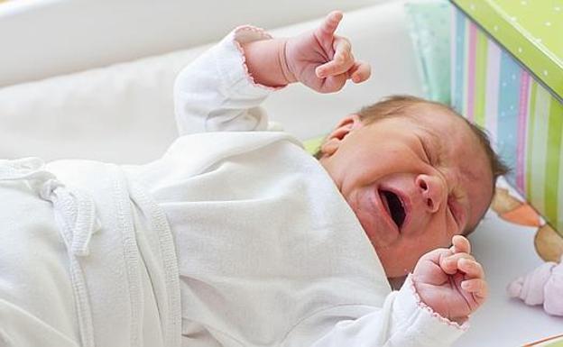 Un bebé llora en su cuna.