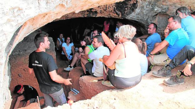 El investigador de la UMU Ignacio Martín Lerma explica a unos visitantes los trabajos de la Cueva del Arco, hace unos días. 