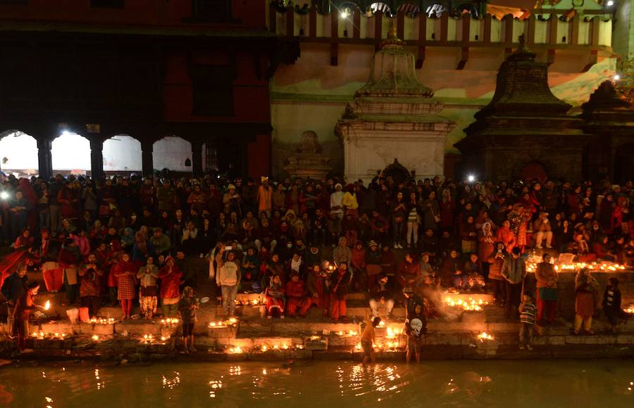 Los fieles hindúes nepalíes encienden lámparas de aceite y siembran siete tipos de semillas alrededor de las instalaciones del templo en nombre de los familiares difuntos.