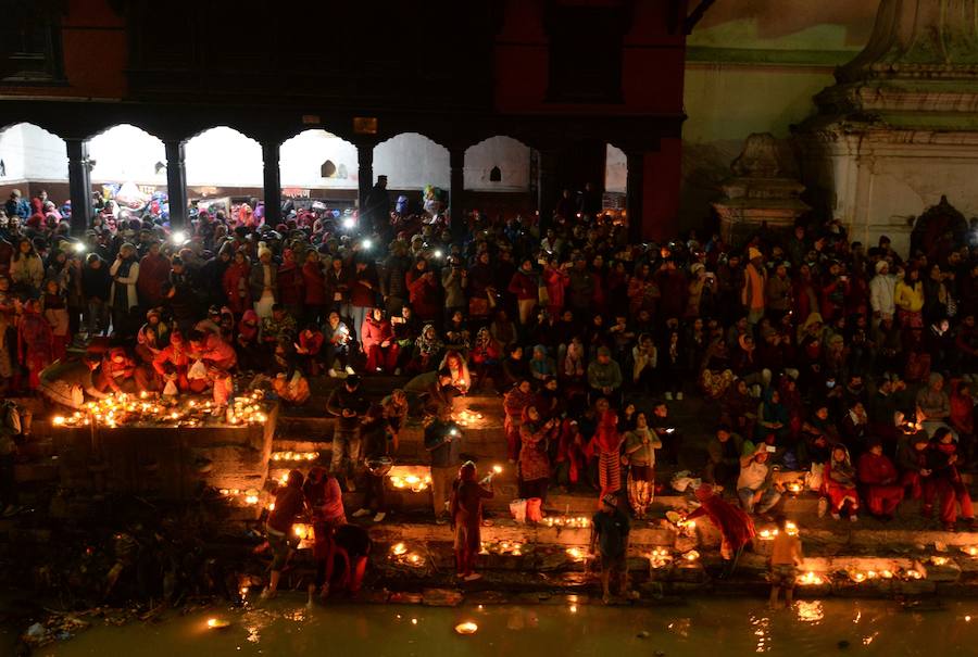 Los fieles hindúes nepalíes encienden lámparas de aceite y siembran siete tipos de semillas alrededor de las instalaciones del templo en nombre de los familiares difuntos.