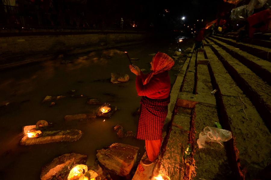 Los fieles hindúes nepalíes encienden lámparas de aceite y siembran siete tipos de semillas alrededor de las instalaciones del templo en nombre de los familiares difuntos.