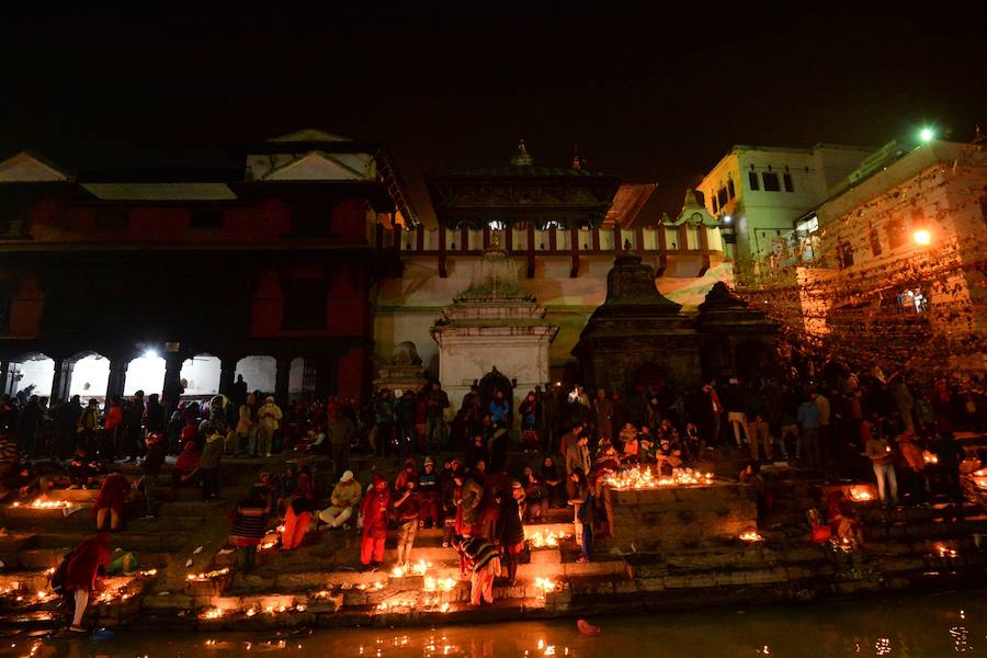 Los fieles hindúes nepalíes encienden lámparas de aceite y siembran siete tipos de semillas alrededor de las instalaciones del templo en nombre de los familiares difuntos.