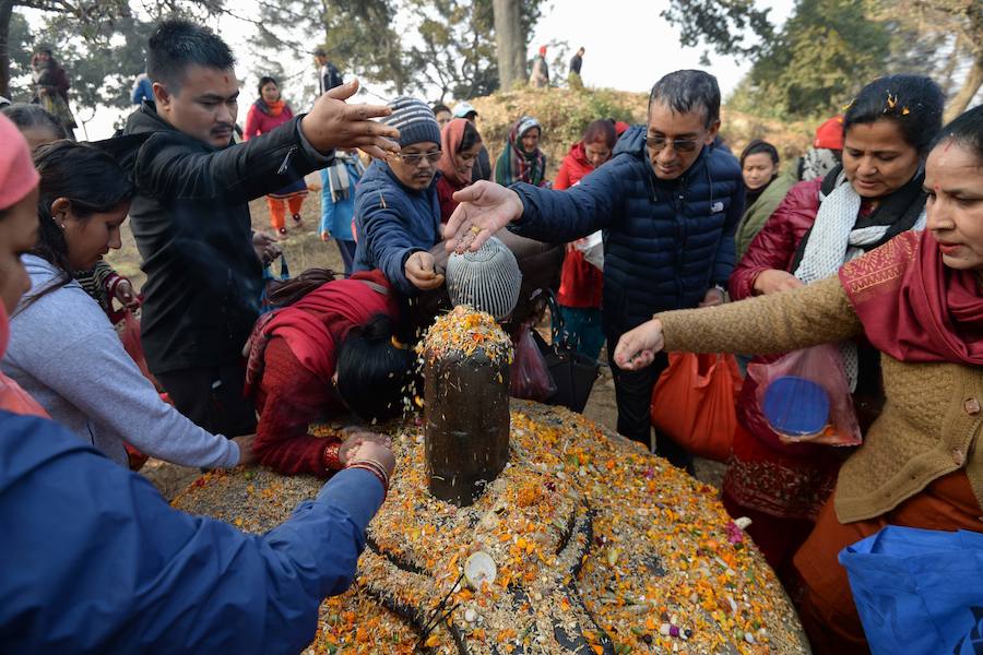 Los fieles hindúes nepalíes encienden lámparas de aceite y siembran siete tipos de semillas alrededor de las instalaciones del templo en nombre de los familiares difuntos.