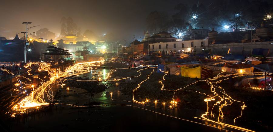 Los fieles hindúes nepalíes encienden lámparas de aceite y siembran siete tipos de semillas alrededor de las instalaciones del templo en nombre de los familiares difuntos.