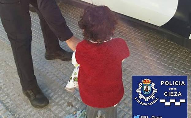Un agente de la Policía Local de Cieza atiende a la niña de dos años que fue encontrada andando sola por el municipio.
