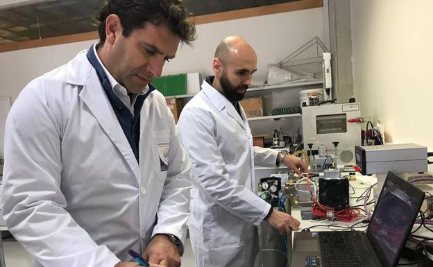 Juan Luis Pedreño, investigador responsable del proyecto, y un trabajador del grupo de investigación en Electromagnetismo y Materia, trabajan en el desarrollo de una secadora de ropa por microondas.