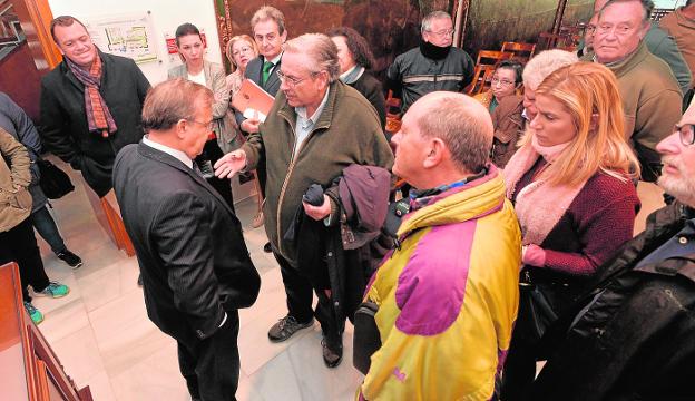 El consejero Patricio Valverde escucha a uno de los damnificados por las ayudas del terremoto tras la firma del convenio, ayer. 