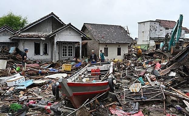 Los aldeanos caminan entre los escombros del tsunami en el pueblo de Sumber Jaya en Sumur, Pandeglang.