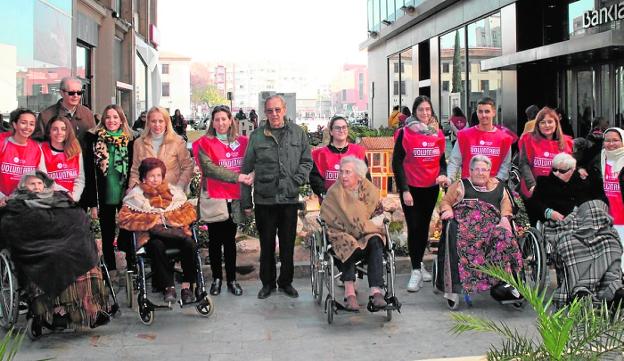 El grupo de mayores y voluntarios, ayer en la calle Almudena, delante del belén de la Fundación Cajamurcia.
