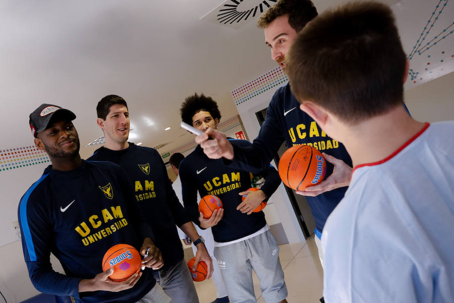 os jugadores de la primera plantilla del UCAM Murcia CB han visitado a los niños ingresados en el Hospital Materno Infantil Virgen de La Arrixaca, y les han entregado balones de baloncesto por cortesía de Arom S.A., uno de los principales patrocinadores del club