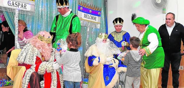 Los niños reciben sus regalos de manos de los Reyes Magos. 