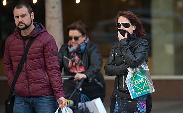 Varias personas pasean abrigadas en Murcia.