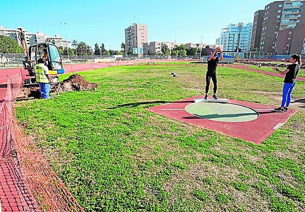 Dos deportistas, a pocos metros de una pala excavadora, ayer. 