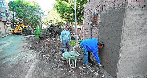 Dos obreros, ayer en el Parque Sauces, reparando la caseta de almacenamiento de enseres de los jardineros. 