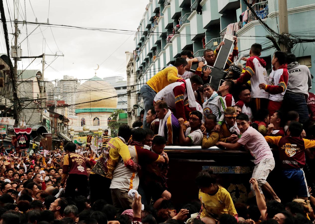 Devotos católicos descalzos empujan durante la procesión en un intento por tocar el Nazareno Negro, una estatua centenaria de un Jesucristo sufriente. Se dice que la estatua de madera de tamaño natural fue traída a Manila (Filipinas), por un sacerdote español.