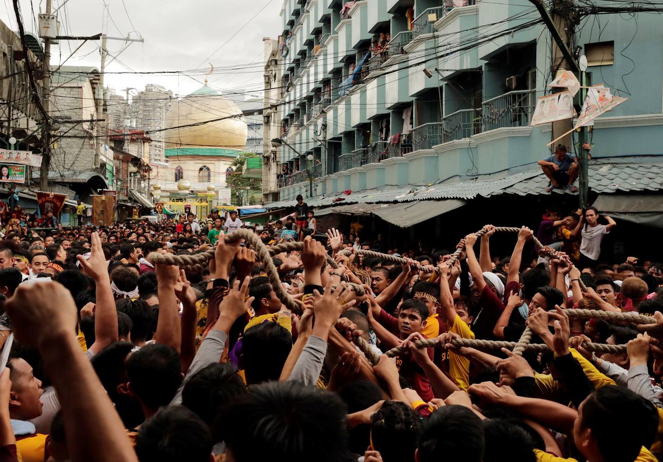 Devotos católicos descalzos empujan durante la procesión en un intento por tocar el Nazareno Negro, una estatua centenaria de un Jesucristo sufriente. Se dice que la estatua de madera de tamaño natural fue traída a Manila (Filipinas), por un sacerdote español.