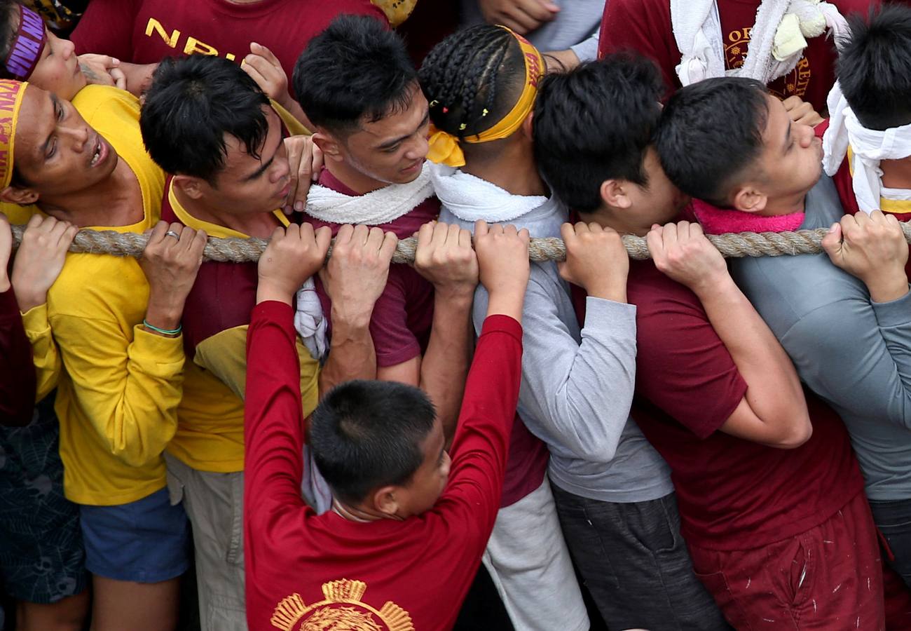 Devotos católicos descalzos empujan durante la procesión en un intento por tocar el Nazareno Negro, una estatua centenaria de un Jesucristo sufriente. Se dice que la estatua de madera de tamaño natural fue traída a Manila (Filipinas), por un sacerdote español.